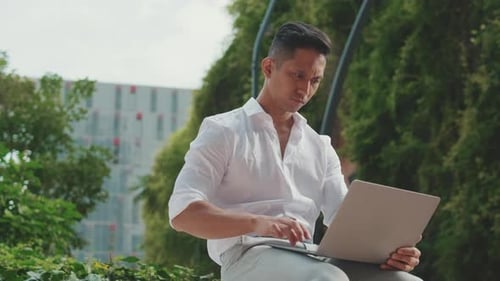 Young businessman using laptop while sitting next to business center