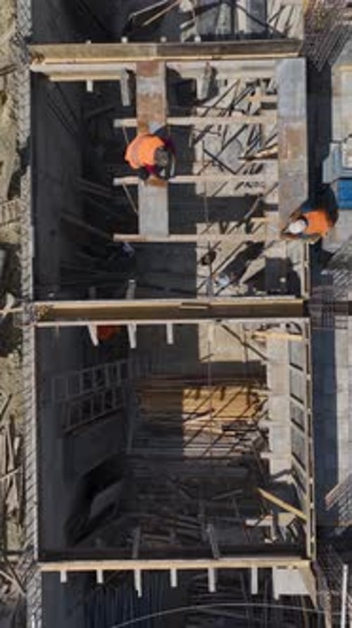 La construcción vertical en vídeo avanza a medida que los trabajadores construyen paredes para pasar a un nuevo nivel con los ingenieros