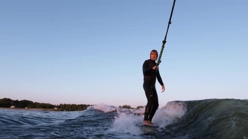 Man Wakesurfing on the Ocean at Sunset