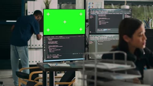 Desenvolvedor de software analisando o Greenscreen e o código do servidor em vários monitores