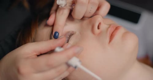 Lashmaker realiza el procedimiento de laminación de pestañas para el cliente en los servicios cosméticos del salón de belleza