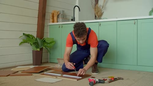 African American Man Assembling DIY Furniture with Screwdriver at Home