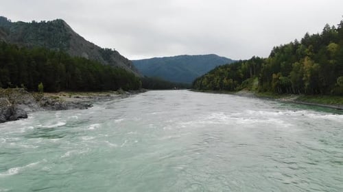 A Tranquil River Its Waters a Unique Shade of Turquoise Flows Through a Dense Forest Flanked By