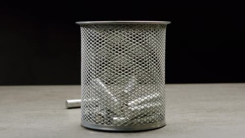 Silver Batteries AA and AAA Falling Into Wastebasket Closeup DoubleA Battery is a Standard Size