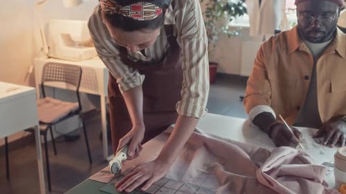 Designers Cutting Fabric and Sketching Together