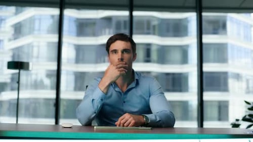 Focused businessman analyzing data on transparent touchscreen in modern office