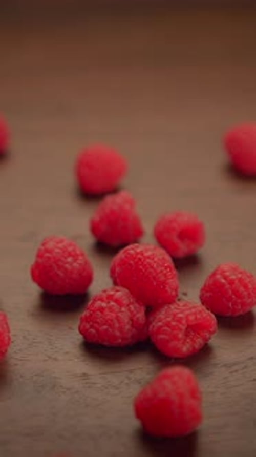 Delightful Scene of Fresh Raspberries Tumbling Gracefully Onto a Rustic Wooden Surface