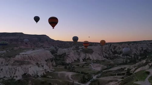 Hot Air Balloons Over Desert Landscape at Sunrise