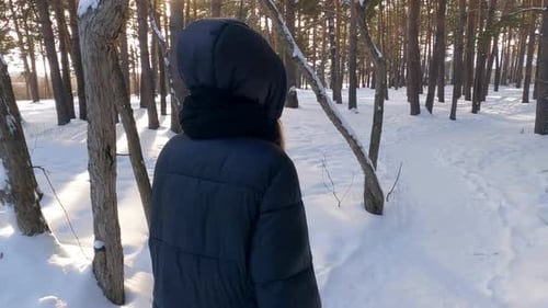 Tracking Shot of Teenage Girl Walking on Snow Covered Field in Park