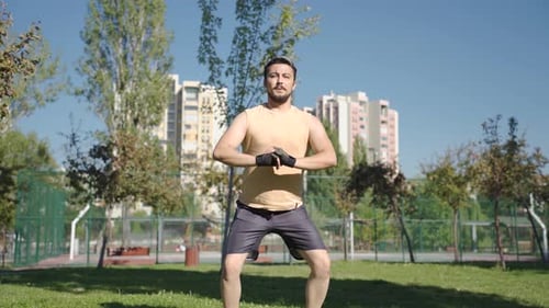 Ambitious and aggressive athlete man doing squats.