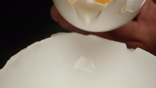 Ich gieße ein rohes Ei von einem Teil der Schale in einen anderen. Dolly Slider extreme Nahaufnahme
.