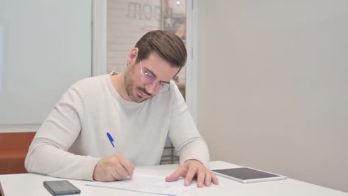 Middle Aged Man Writing a Letter in Office
