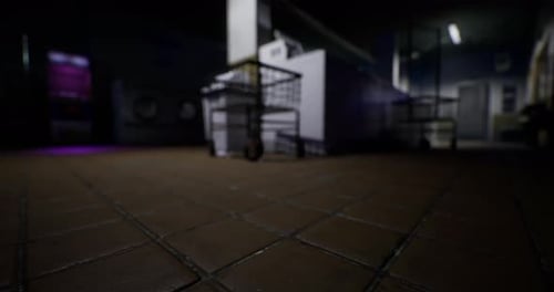 Inside a Dimly Lit Kitchen with Tiled Floor and Steel Equipment at Night