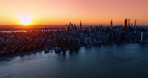 Bright setting sun sending last rays on the scenery of New York. Golden hour in metropolis from top.