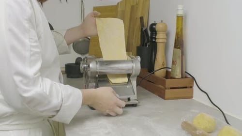 Chef Using Pasta Machine in Bright Kitchen