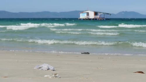 Waves Brushing at the Beach with View of Blue Sea Island and Floating Cottage
