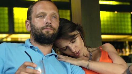 Drunk, Tired Couple Drinking Beverage And Talking Sitting On Sofa In Cafe