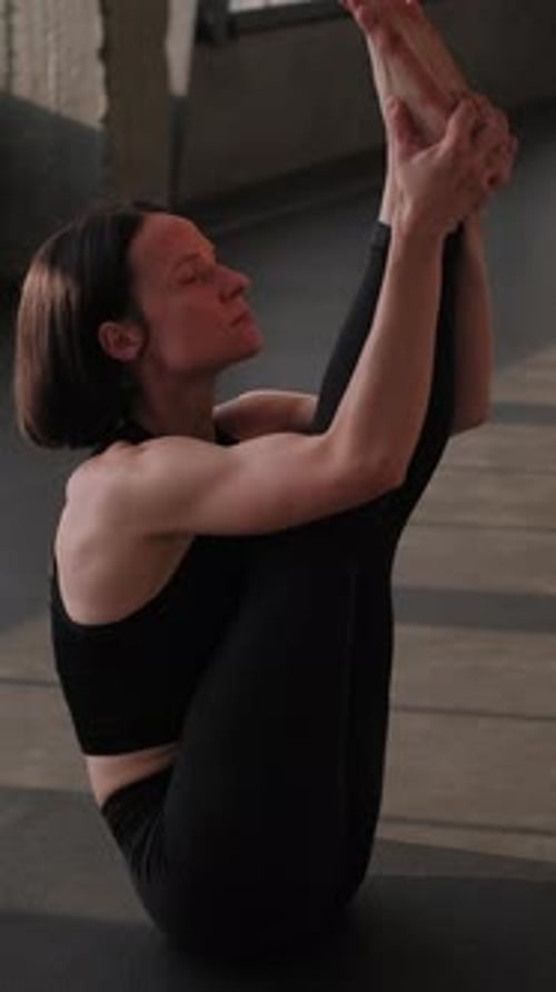 Woman Practicing Extreme Yoga Leg Stretch Indoors