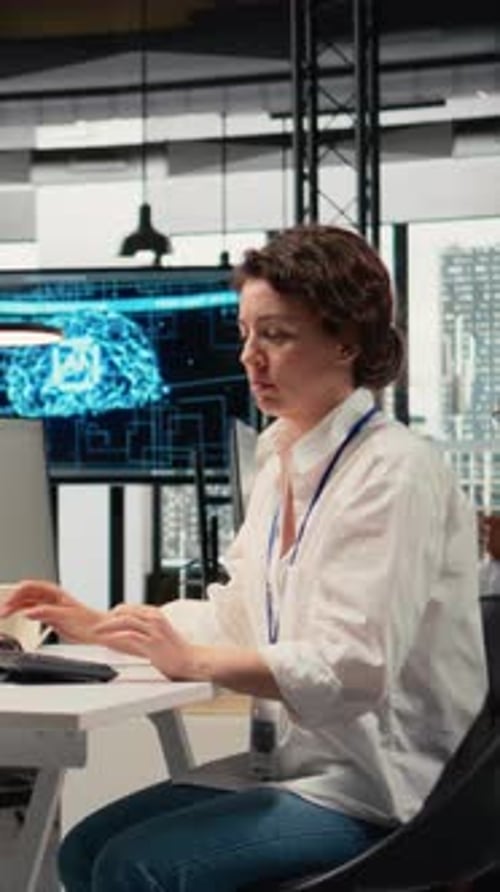 Woman Working at Computer in Modern Office Wearing Headphones