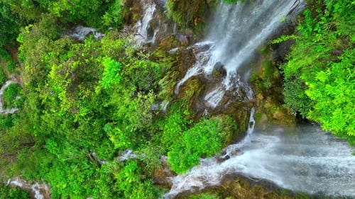 Beautiful waterfall in a tropical forest by aerial view from a drone.