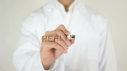 Person Writes the Word Health on Clear Surface