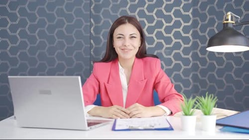 Smiling Woman at Desk in Corporate Office