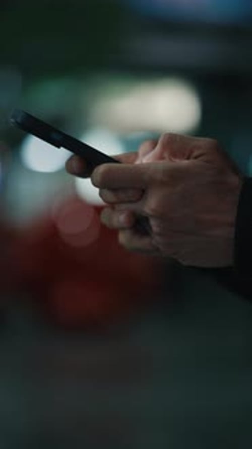 Hands of Male Person Using Phone While Searching for Application Close Up Night Time Vertical Video