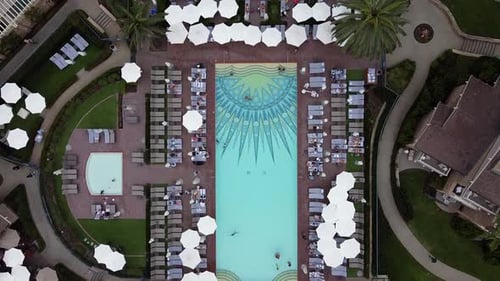 Luxuriöser Resortpool. Menschen schwimmen, entspannen und sich sonnen. Luftbild von oben nach unten