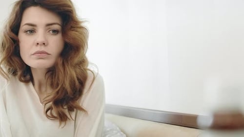 Worried Woman Holding Pills Indoors in the Daytime