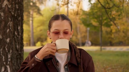 Woman Drinking Tea in Park During Autumn