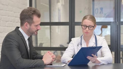 Doctor Discusses Diagnosis with Male Patient in Office
