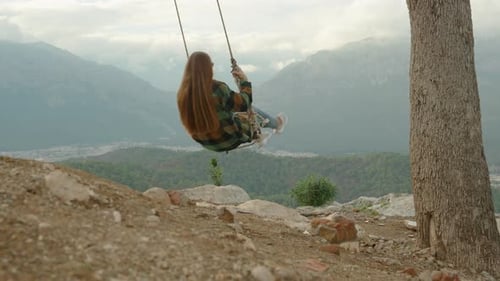 Homemade swings at the mountain summit, suspended over the abyss and tied to a tree branch.