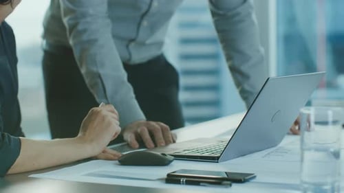 Close-up Shot of Anonymous Businesswoman and Businessman Discussing Project and Using Laptop Comput