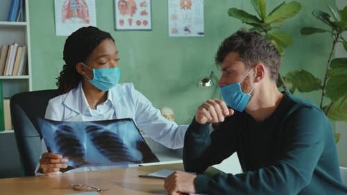 Doctor Reviews X-Ray with Patient in Office