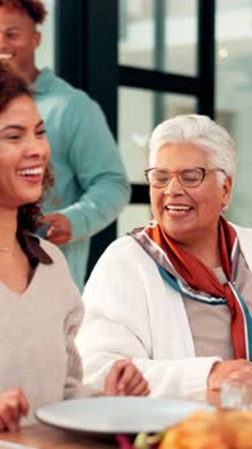 Family Gathered Around Table Talking and Laughing