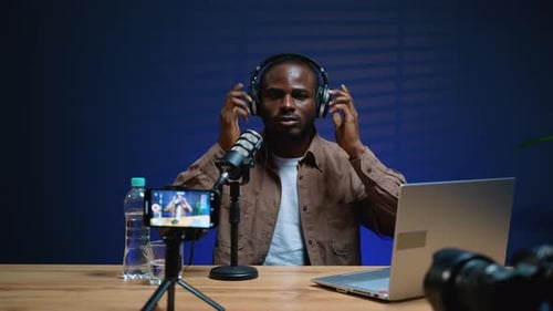 Man Records Podcast with Microphone and Headphones