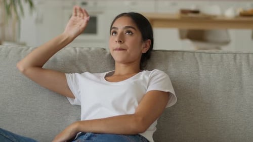 Woman Fanning Herself Due to Heat Indoors