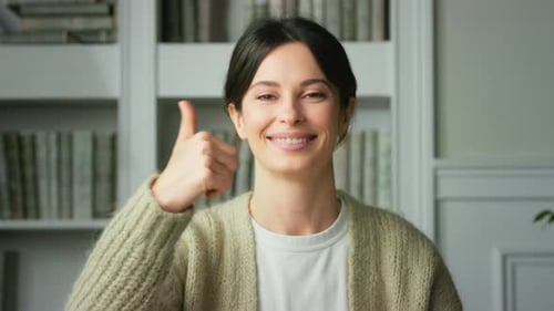 Smiling Woman Gives Thumbs Up Gesture Indoors