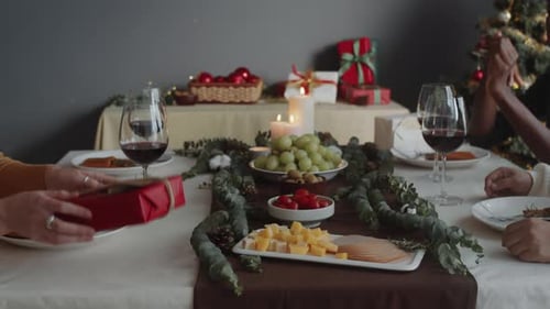 Friends Exchanging Gifts at Christmas Table
