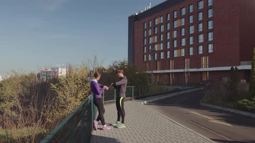 Two Young Adults Resting After a Run Outdoors
