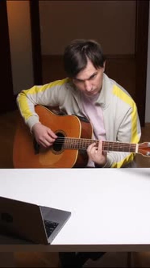 Young Adult Plays Guitar at Home