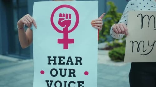 Young Adults Standing with Feminism and Equality Signs
