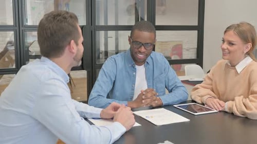 Three Adults in Office Collaborate