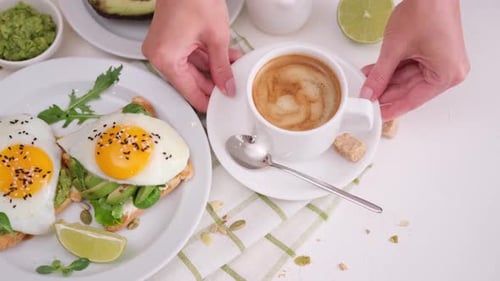Hands Place Coffee Next to Healthy Avocado Toast