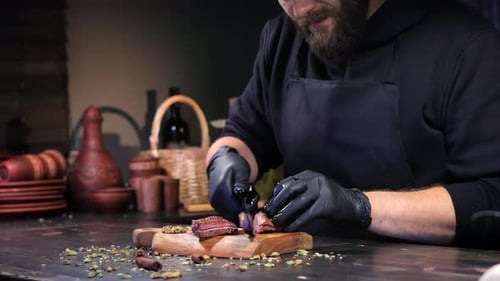 Male Chef Slicing Fresh Cooked Grilled Meat Steak Fillet Use Knife Wooden Board at Rustic Restaurant