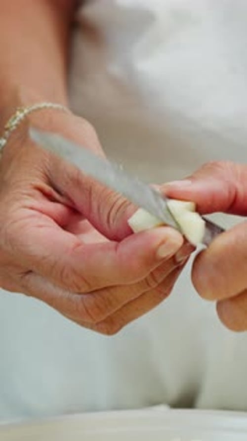 A Womans Hands Cut Provola Cheese Into Pieces for Emilian Lasagna