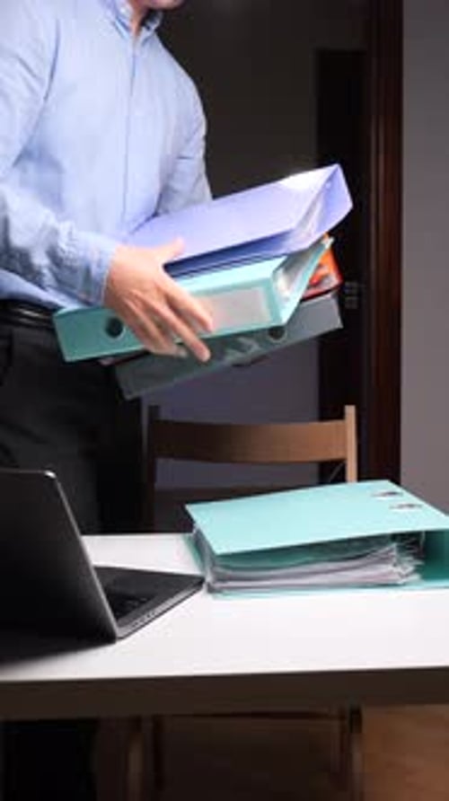 Man Stacking Files in Office Workplace