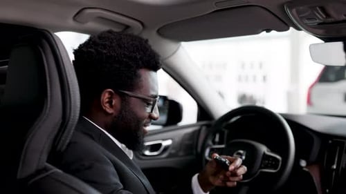 Businessman Buying Car at Dealership Sitting Inside Vehicle
