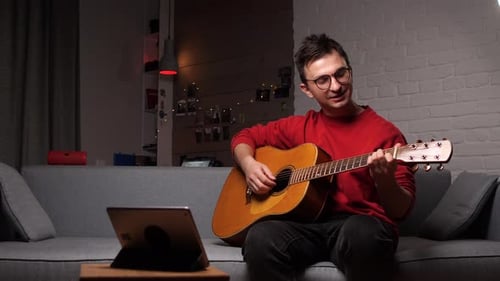 Young Adult Sings and Plays Acoustic Guitar