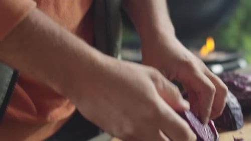 Mann zerkleinert Rotkohl mit Messer